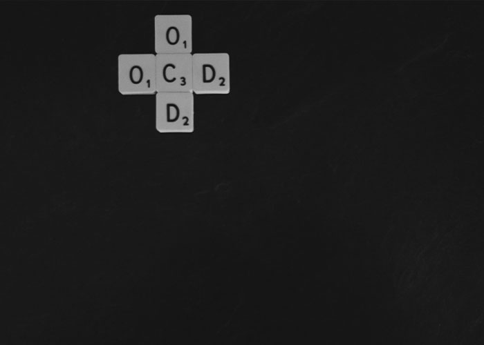 Scrabble tiles spelling OCD, symbolizing the challenges Jim Parsons faced and the steep personal price of fame. Scrabble tiles spelling OCD, symbolizing the challenges Jim Parsons faced and the steep personal price of fame.