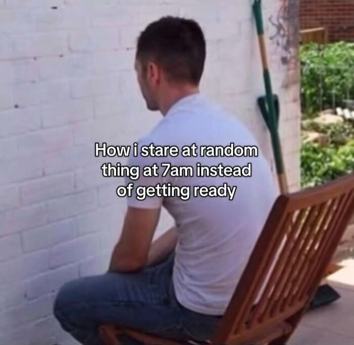 A man staring blankly at a wall, depicting relatable morning routine procrastination in entertaining memes.