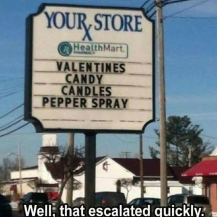 A store sign advertising Valentines candy, candles, and pepper spray, indicating a cultural decline into idiocy.