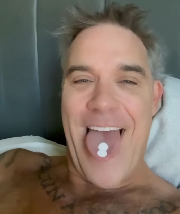 Robbie Williams breaks silence after the World Cup moment, playfully showing two pills on his tongue. Robbie Williams breaks silence after the World Cup moment, playfully showing two pills on his tongue.