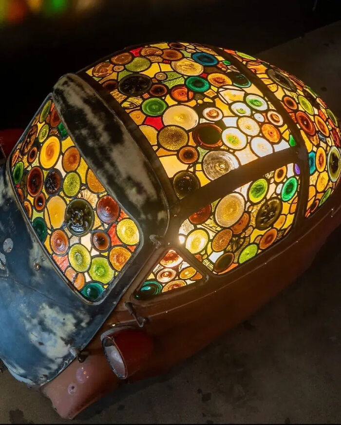 Illuminated stained-glass sculpture on a Porsche 911, showcasing the vibrant colors and extraordinary art.