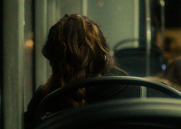 A person with long hair looks away, perhaps pondering moments when reality break.