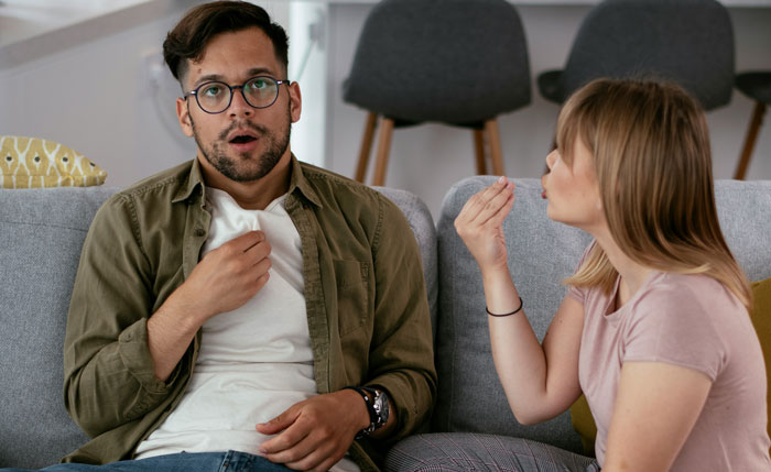 A man looking shocked while a woman gestures, illustrating common men's complaints in relationships.