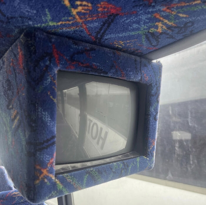 A small, old-fashioned television screen embedded in a bus ceiling, a throwback meme for 90s kids.