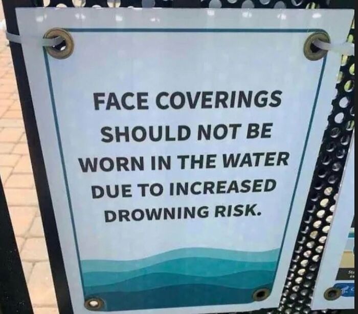 A sign warning that face coverings should not be worn in water due to drowning risk, highlighting cultural decline.