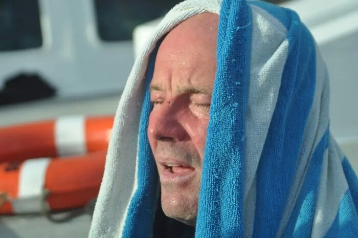 A man with a towel draped over his head, showcasing fascinating things about the world.