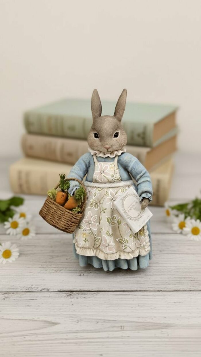 Handmade cotton wool creation of a rabbit in an apron, holding a basket of carrots, by an artist who creates art.