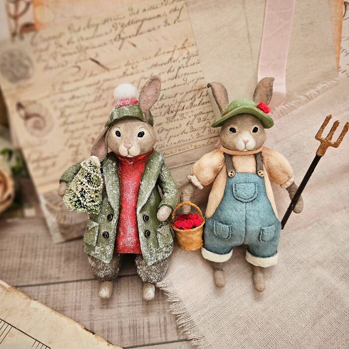 Two handmade cotton wool bunny creations, one in a green coat with a bouquet, the other in overalls with a basket and pitchfork.