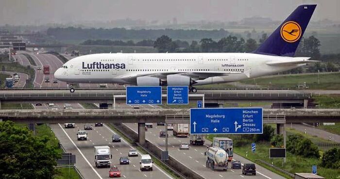 A massive Lufthansa plane appears to pass over a highway full of cars, making your brain question if it was edited.