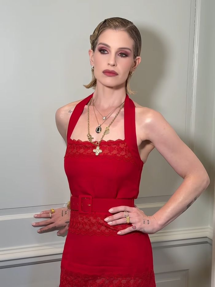 A woman in a red halter dress with a belt and lace trim, posing with her hands on her hips, showing a body type men really want. A woman in a red halter dress with a belt and lace trim, posing with her hands on her hips, showing a body type men really want.