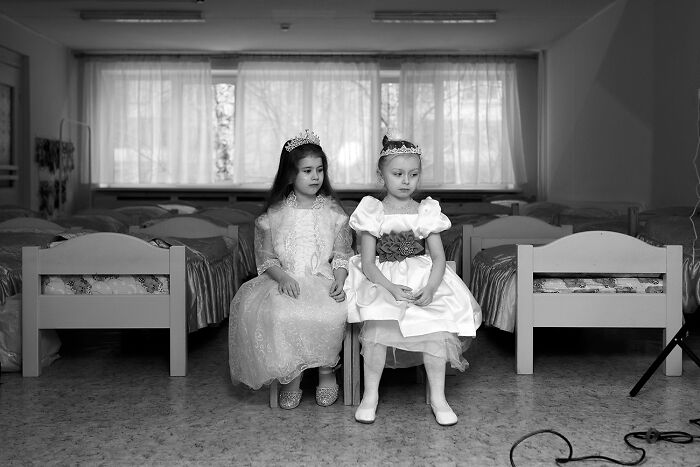 Best black and white photographs featuring two young girls in dresses and tiaras, sitting in a room with rows of beds.