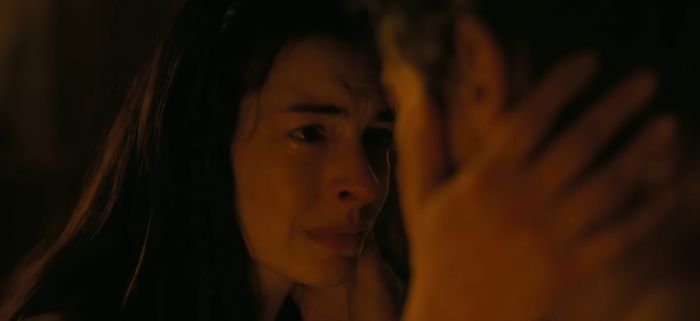 A woman crying, illuminated by a warm glow. This image is related to The Odyssey film adaption.