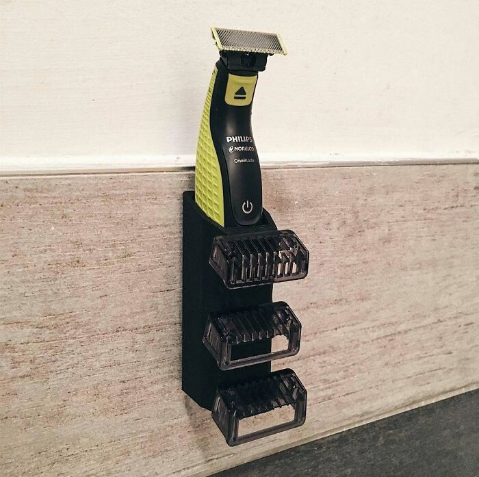 Wall-mounted 3D printing holder for a Philips Norelco OneBlade shaver, a practical creation.
