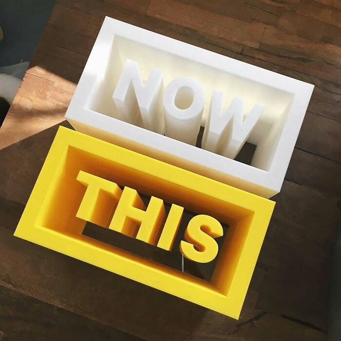 Amazing 3D printing creations: two framed words, NOW in white and THIS in yellow, crafted with 3D printing.