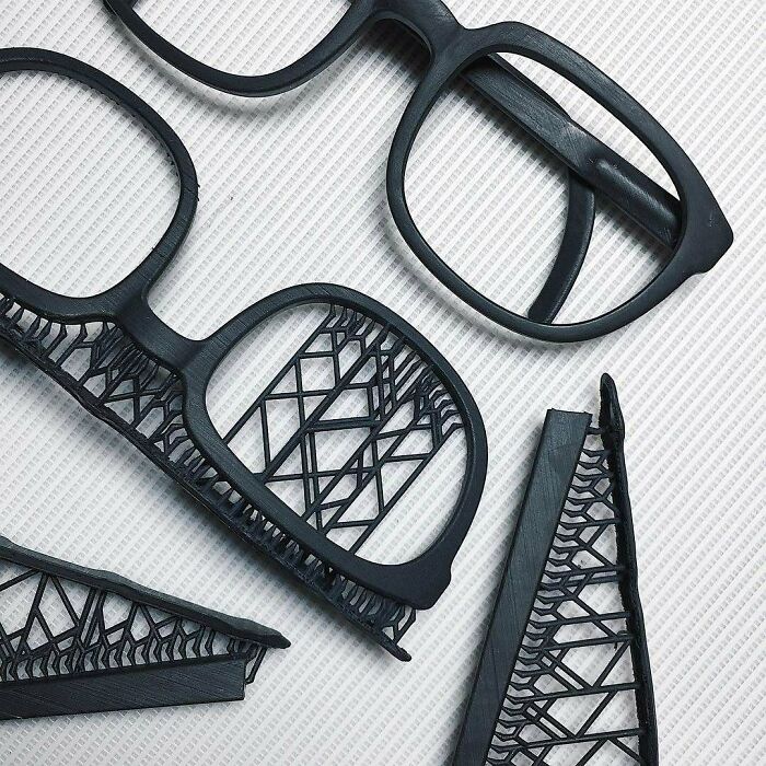 Amazing 3D printing creations: black glasses frames with intricate, delicate lattice designs.