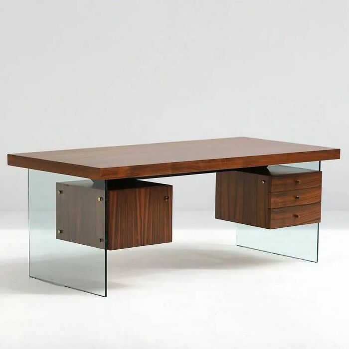 A brilliant design choice: a modern wooden desk with transparent glass legs and floating drawers, creating an elegant and airy feel.
