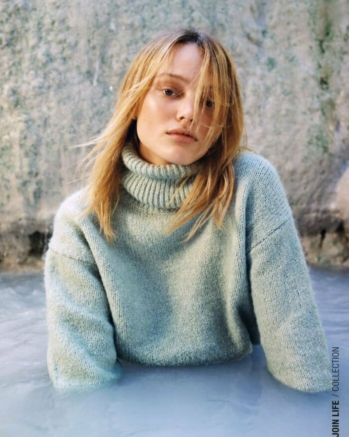 A person in a light blue turtleneck sweater partially submerged in water, part of Zara website's bizarre content.