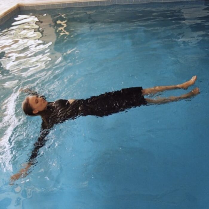 A woman floats on her back in a swimming pool, illustrating bizarre content from Zara.