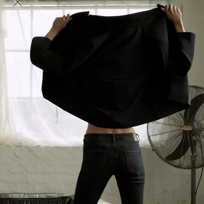 Person in black jeans taking off a black jacket, bizarre Zara website content.