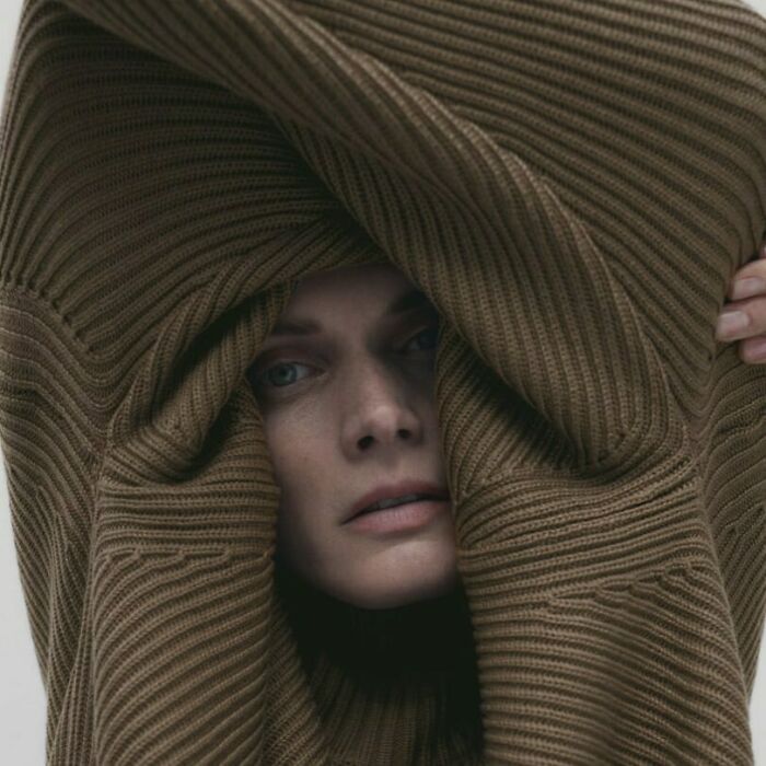 Woman looking through a large brown knitted sweater, bizarre Zara website content.