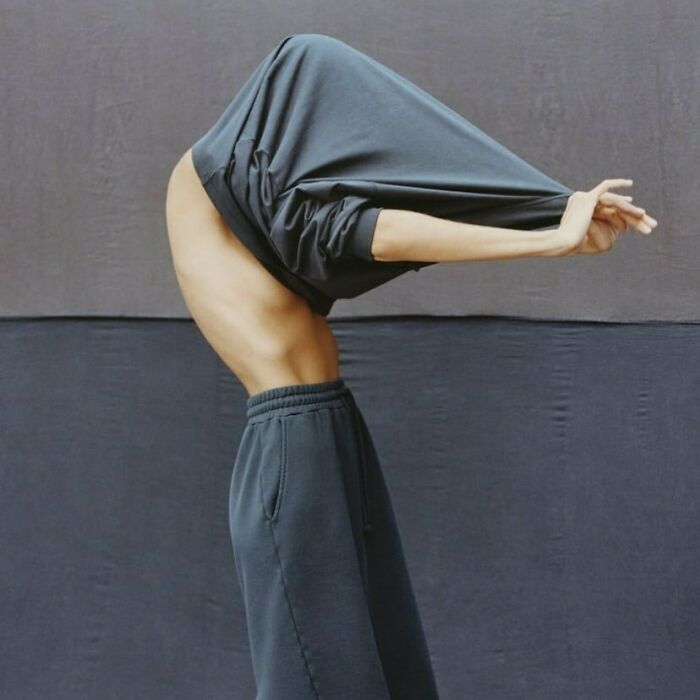 A person in athletic wear, bending backward while pulling a shirt over their head, odd content on the Zara website.