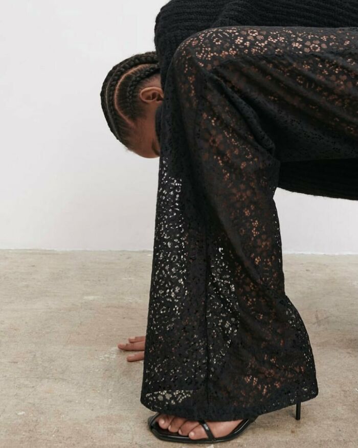 A person in black lace pants bent over, with hands on the floor, found in bizarre content on the Zara website.