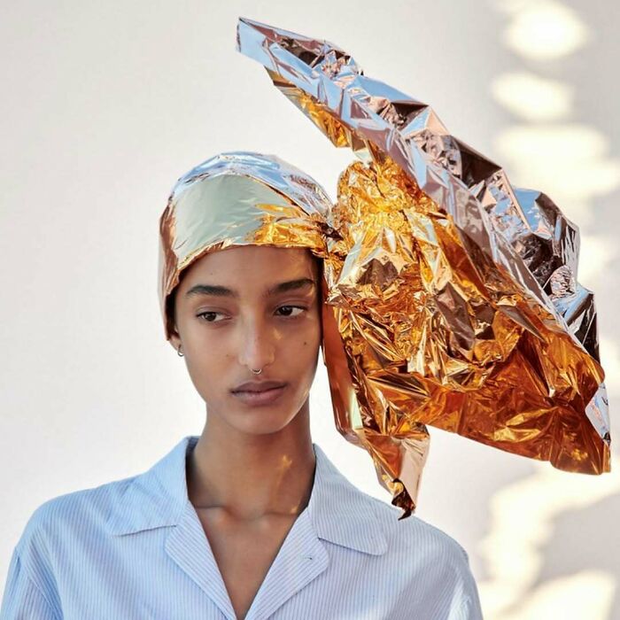 A woman wearing a metallic foil headpiece, part of the hilariously bizarre content on Zara website.