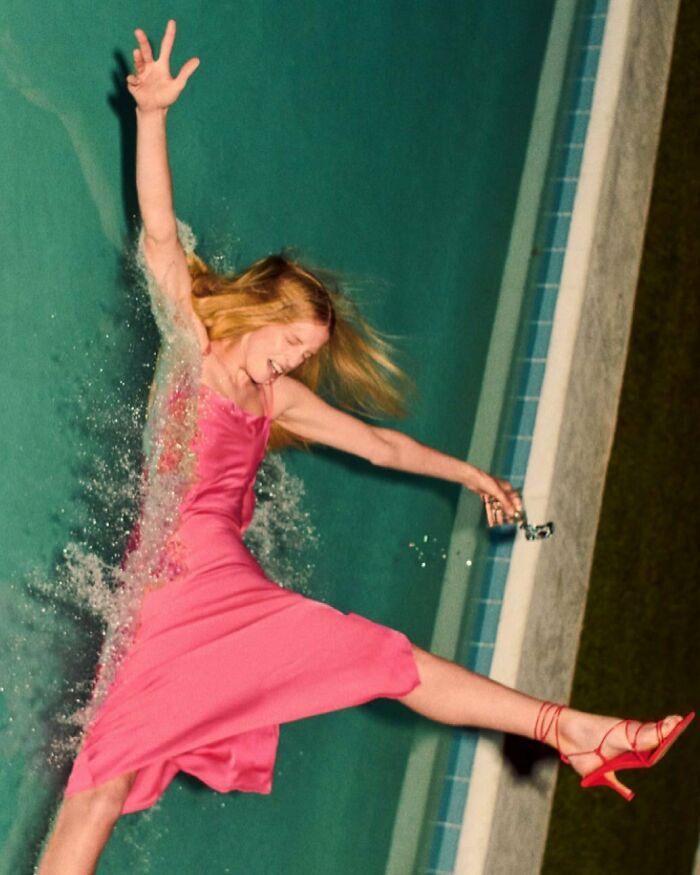 A woman in a pink dress falling backward into a swimming pool, illustrating bizarre content on the Zara website.