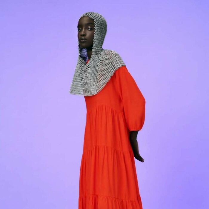 Model in a red dress with a chainmail hood, bizarre Zara content.