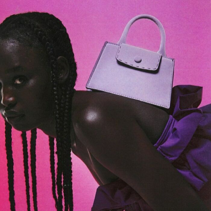 Bizarre content on Zara website: a model with a small purple bag on her back against a pink background.