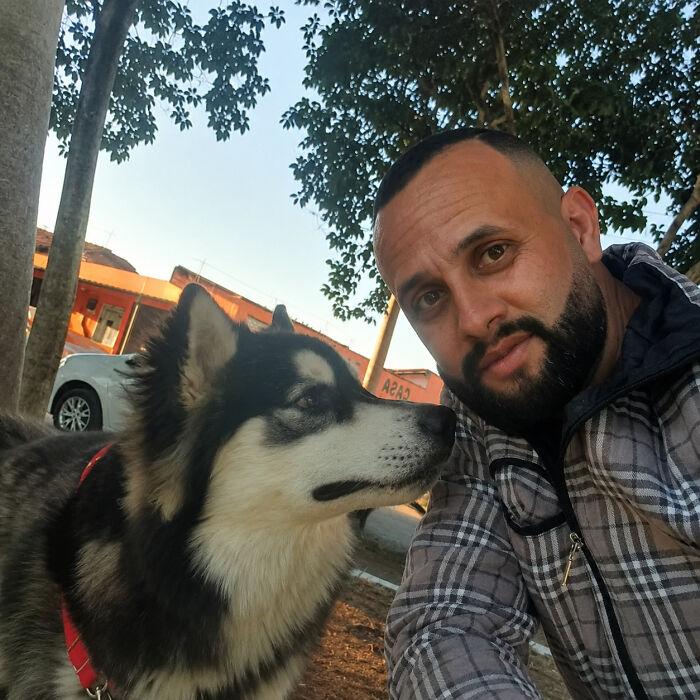 A kind mailman takes a selfie with a beautiful husky, stopping to befriend dogs during his deliveries.
