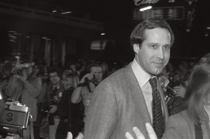 Chevy Chase smiling amidst a crowd, a favorite celebrity moment related to disillusionment.