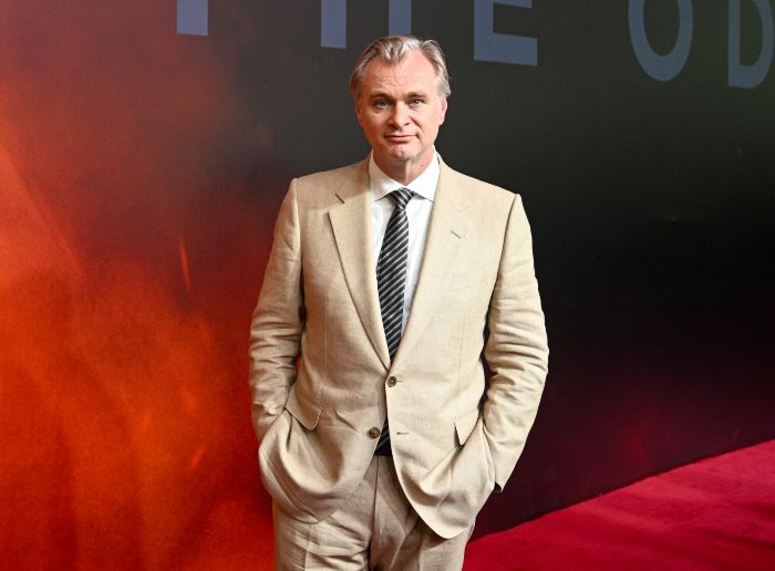 Christopher Nolan, director, standing on a red carpet, ready to talk about The Odyssey translator's review.