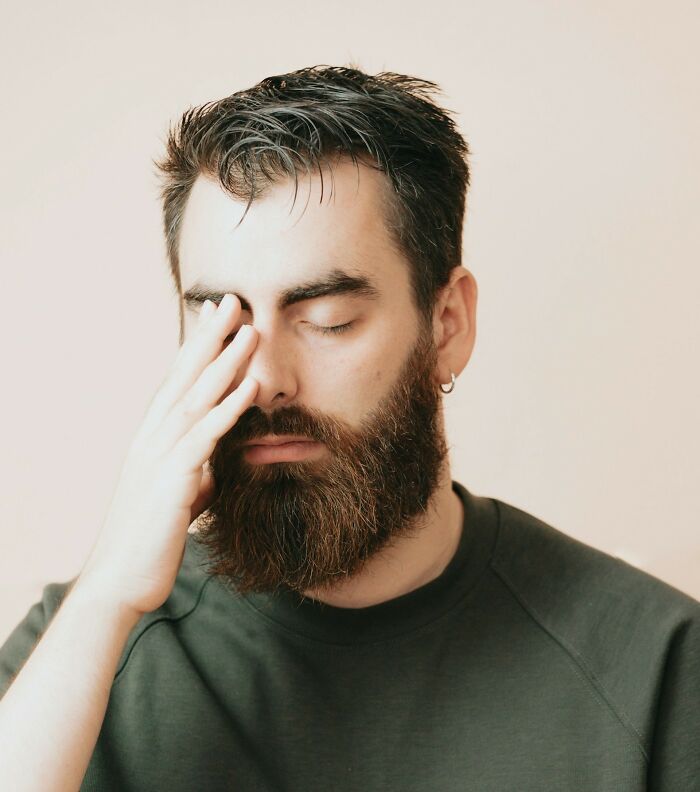 A man with a beard and closed eyes, hand covering his face. This image reflects the intensity of comebacks.