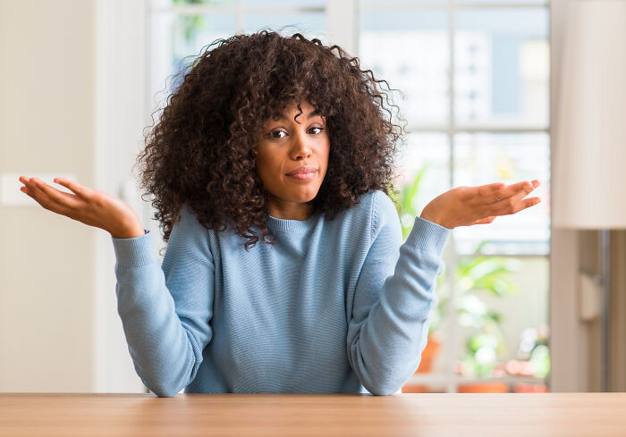 A woman shrugging with a confused expression, perhaps after an amazing comeback or insult.