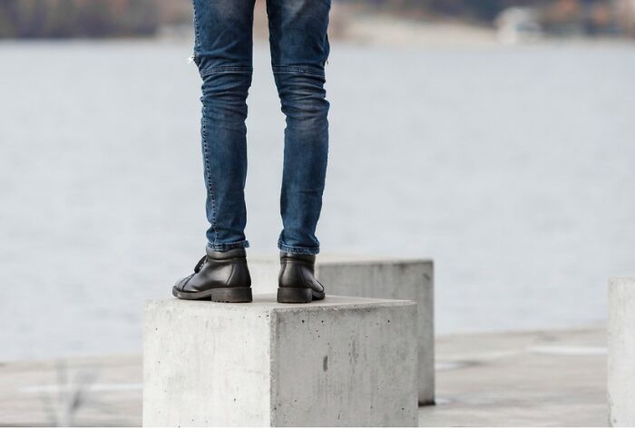 A person standing on concrete blocks with a water background, symbolizing making amazing comebacks.