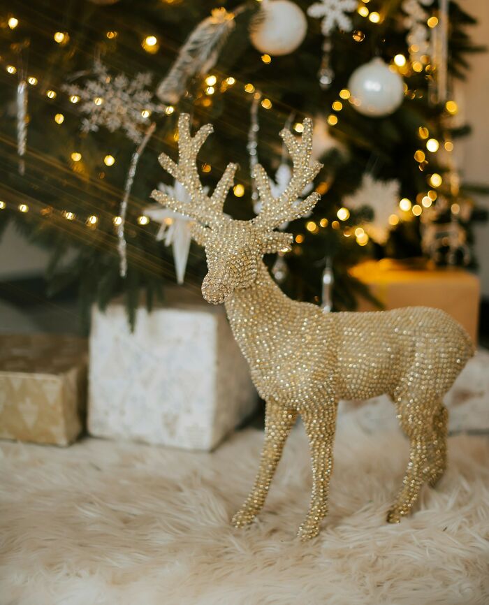 A golden reindeer decoration under a Christmas tree, symbolizing childhood memories that still give people chills.