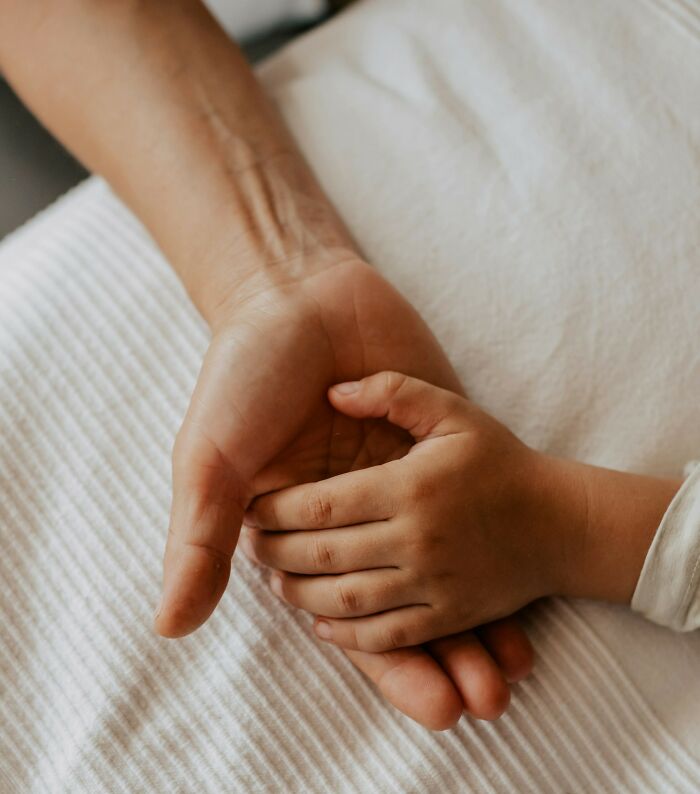 A parent holding a childs hand, symbolizing unsettling childhood memories that still give people chills.