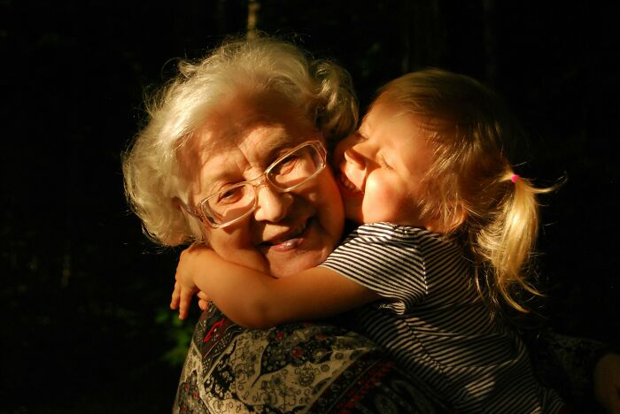A happy young girl hugging an older woman, a comforting image contrasting unsettling childhood memories.