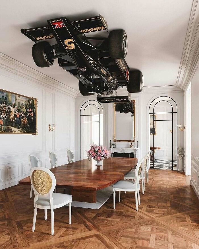 A racing car brilliant design mounted upside down on the ceiling of an elegant dining room.