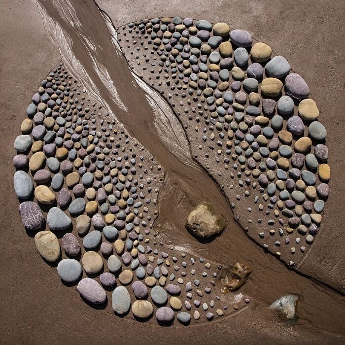 A brilliant design choice of a natural art piece made with small rocks and a stream forming a circle.