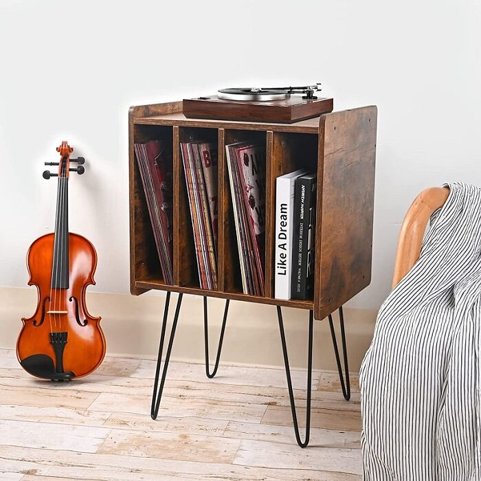 Record player on a brilliant design choices table for vinyl records next to a violin.