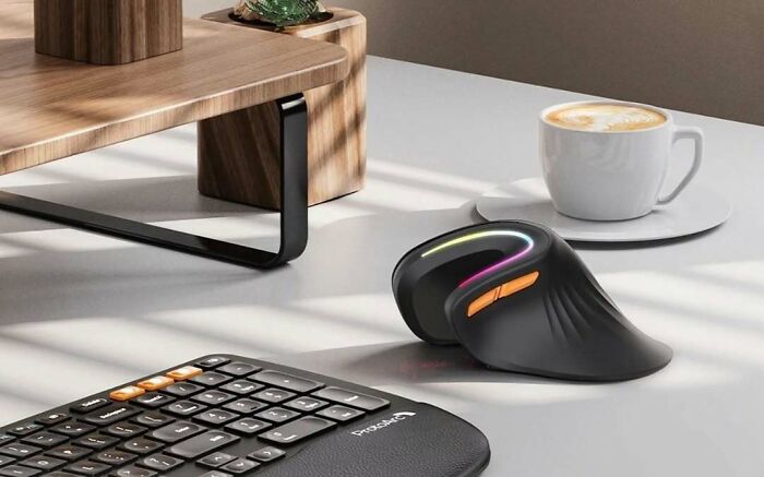 An ergonomic computer mouse and keyboard, reflecting brilliant design choices for comfort and style, next to a coffee.
