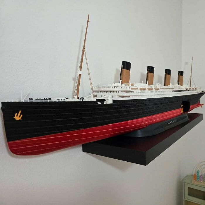 An impressive 3D printing creation, a detailed model of the Titanic, elegantly displayed on a wall-mounted shelf.