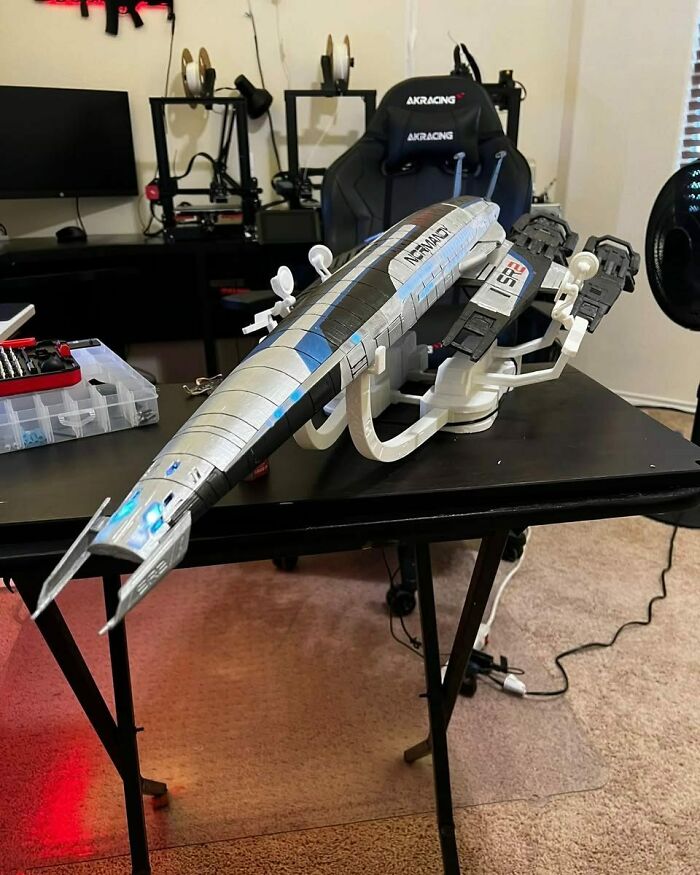 An impressive 3D printing creation of the Normandy SR-2 spaceship on a desk, an amazing 3D printing fan creation.