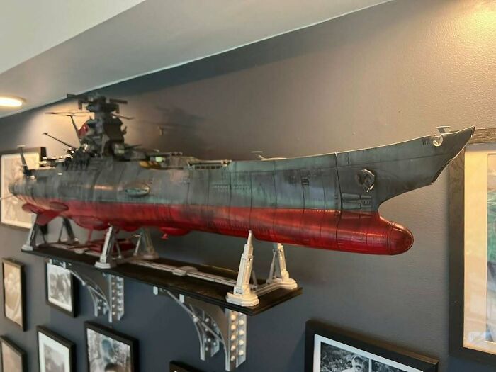 A stunning 3D printing creation, a large battleship model, mounted on a wall shelf, showcasing intricate details.