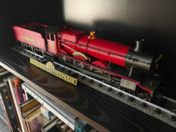 A detailed 3D printing of the red Hogwarts Express train on a track, a fan's amazing creation.