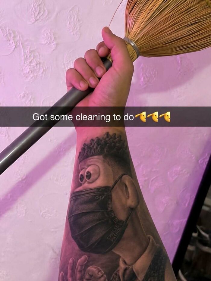An arm tattoo of a masked cartoon character holding a broom, part of cringe memes.
