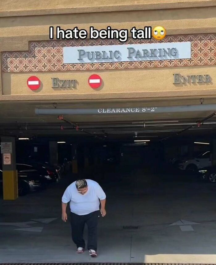 A cringe post featuring a person who is not tall walking into a parking garage with a sign that says 'I hate being tall'.