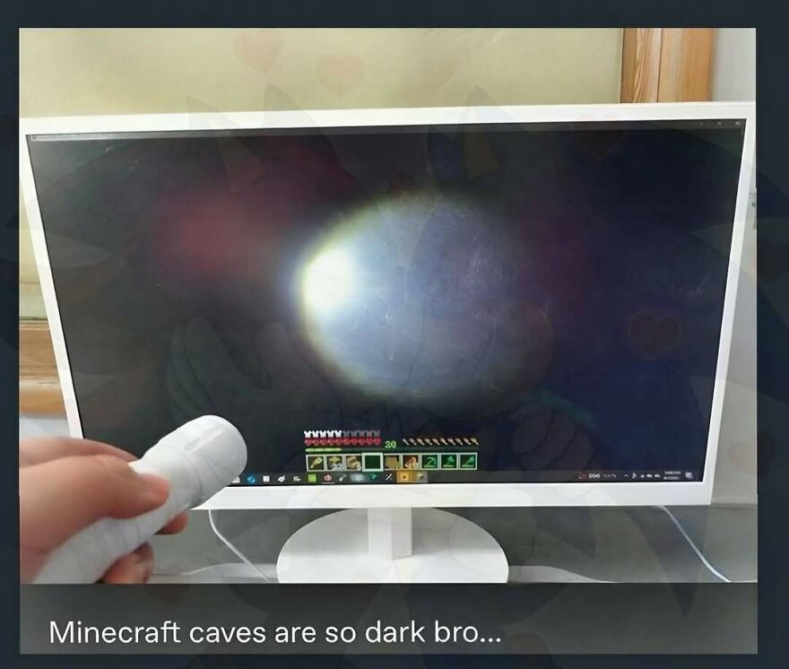 Funny screenshot of a person holding a flashlight up to a monitor playing Minecraft due to dark caves.